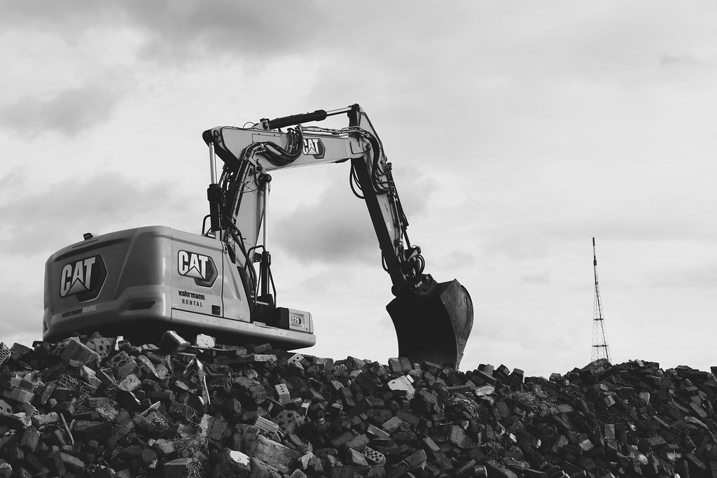excavator on a pile of rubble
